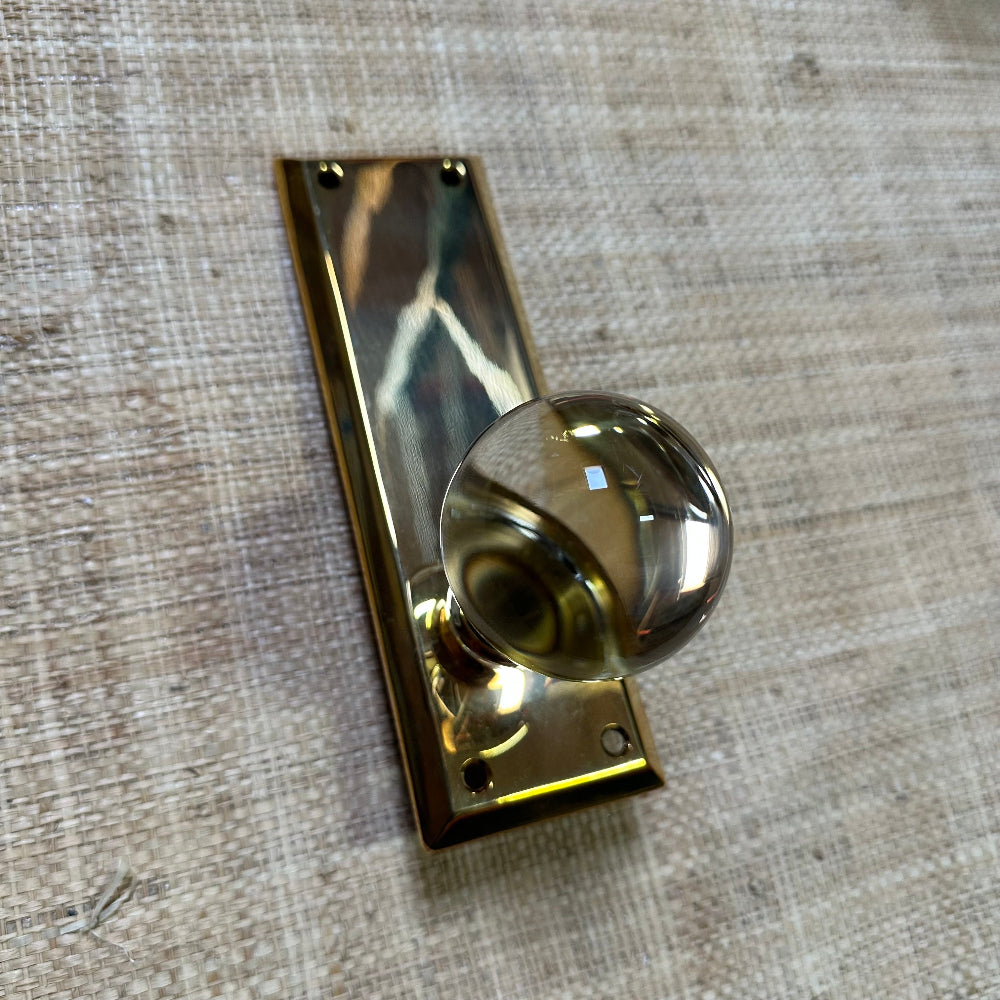 Gold door handle on a textured beige background