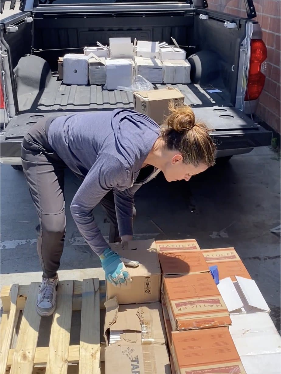Unbuilt staff unloading boxed tile from a pickup truck onto a pallet