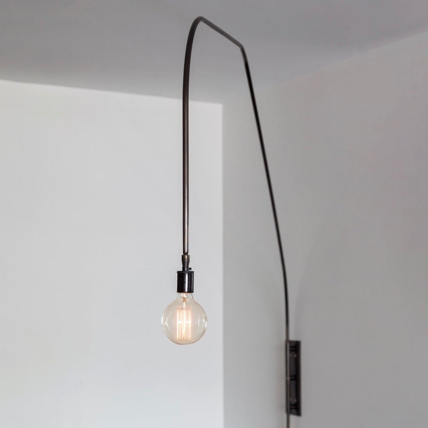 Lumifer Switch Long Arm Sconce in oil rubbed brass with black leather wrap