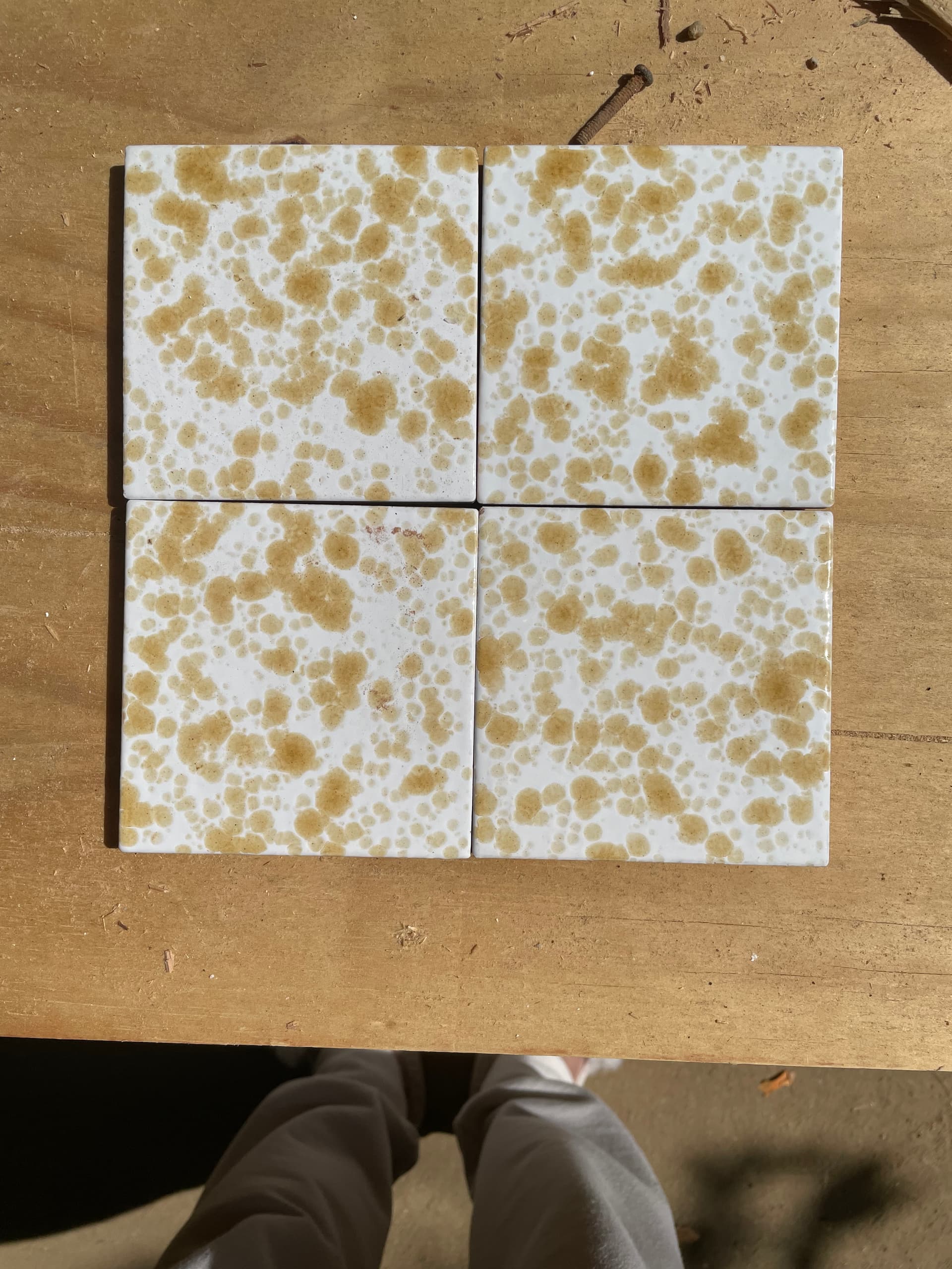 Italian hand-made 4" x 4" ceramic tile with mottled amber and yellow design on white background